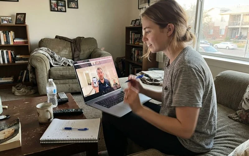A person video-calling a Houston leasing office for a virtual apartment tour before an out-of-state move